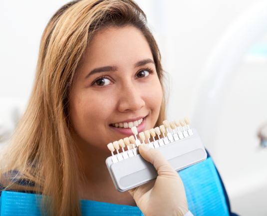 Patient matching tooth shade with a smile guide.