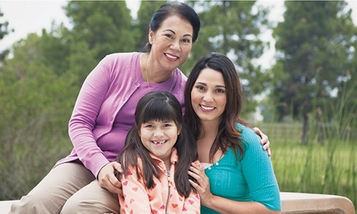 A mother, her daughter and grandmother sitting together all smiling