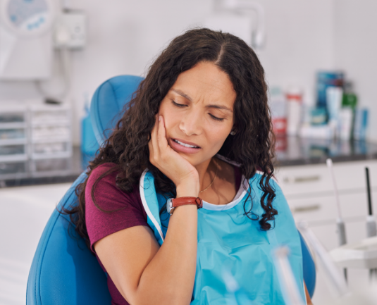 Patient holding her jaw from tooth pain.