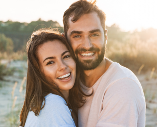 Smiling couple with healthy smiles outdoors.